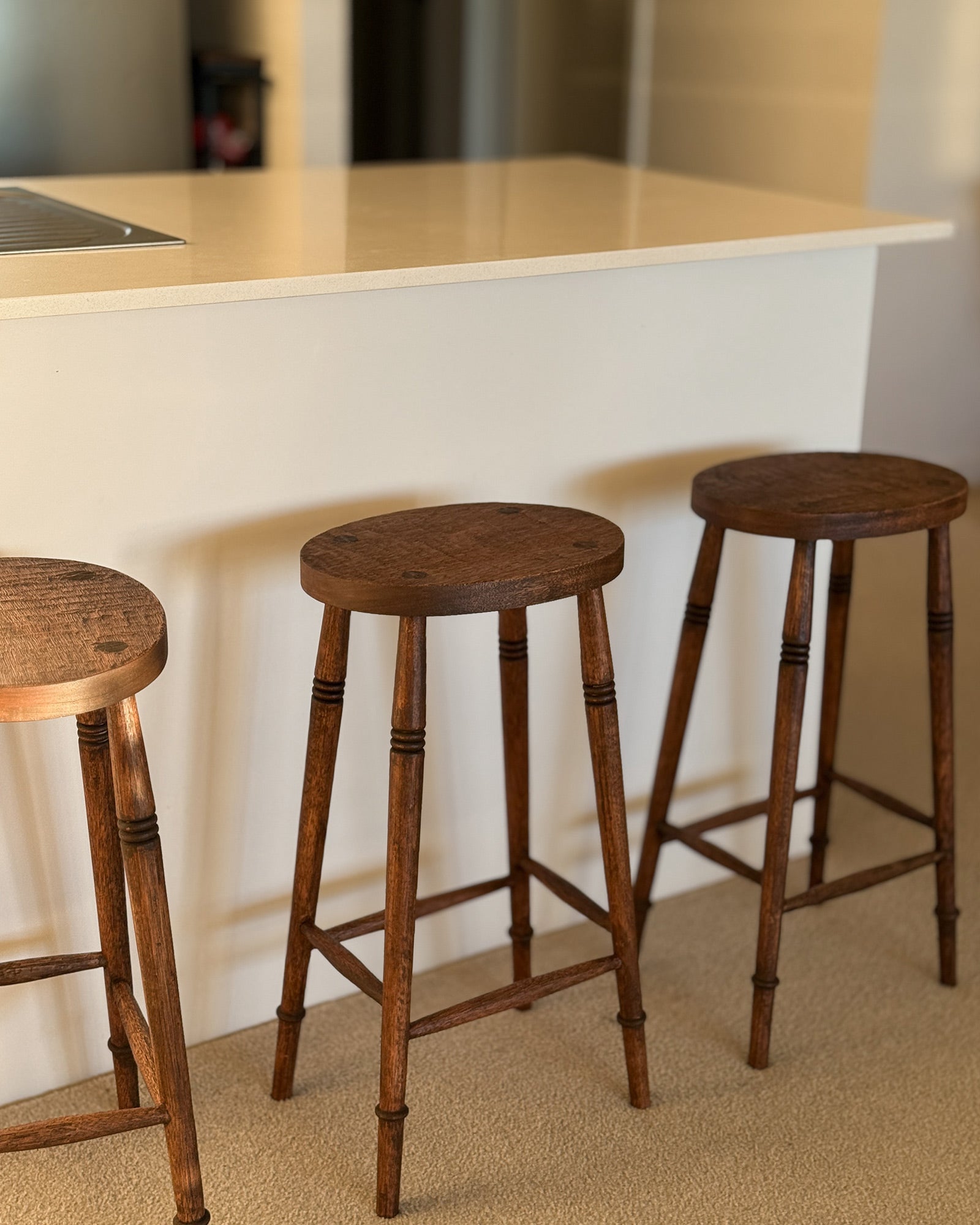  Alo Oval kitchen bar stools styled at a white kitchen island bench, handmade timber with turned legs, Sydney